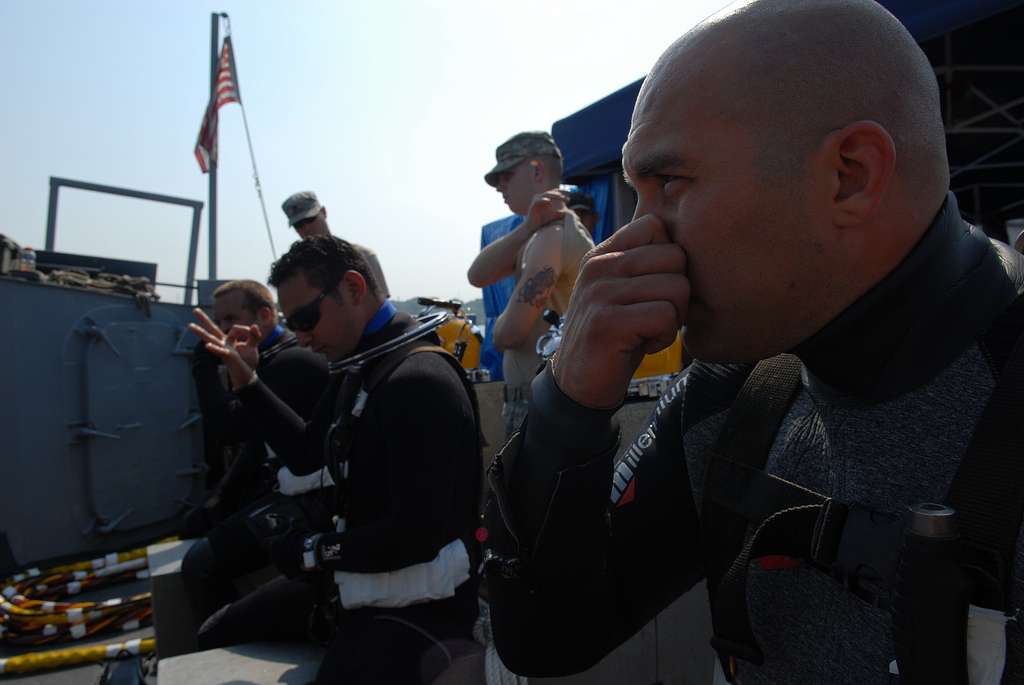 US Nvy divers pre-pressure their ears before diving to make equalization easier on descent
